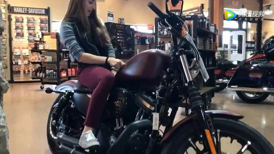 漂亮女孩在车店试骑哈雷戴维森摩托车,美女