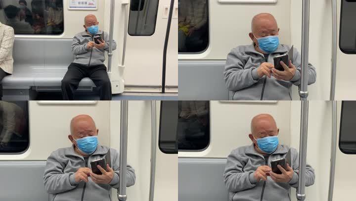 疫情期间一位老人在地铁上认真看手机