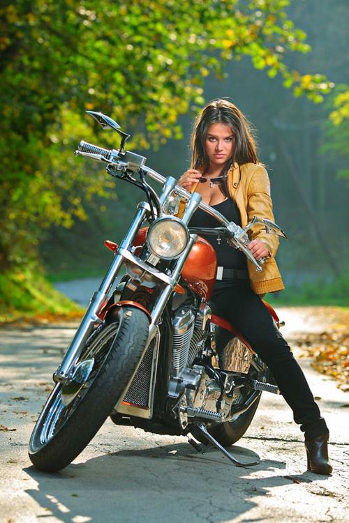 骑在摩托车上手拿墨镜的美女高清图片