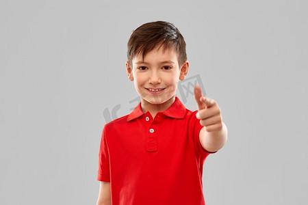 手势和人的概念-微笑的年轻人在条纹 t 恤指着相机在灰色的背景.