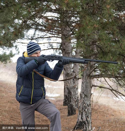 冬季森林里的白种人瞄准目标.用猎枪打猎