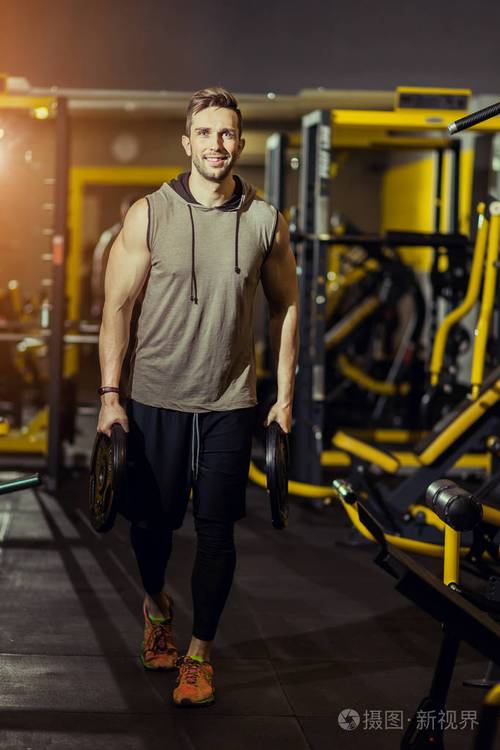 概念力量健康生活方式运动强壮肌肉男在健身房锻炼,用重量盘做冲刺
