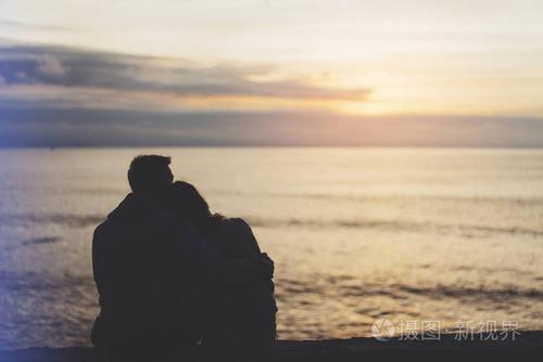 情侣拥抱背景沙滩海洋日出约会情侣概念剪影两个浪漫的人拥抱看风景