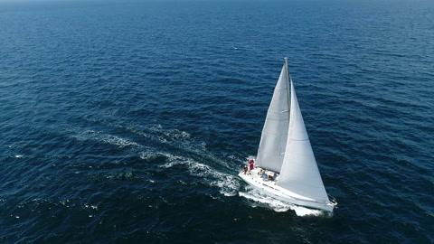 一艘白色帆船在海浪中快速行驶在海洋中的船上飞行