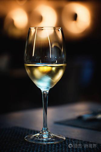 酒杯在桌子上放了一杯白葡萄酒.特写