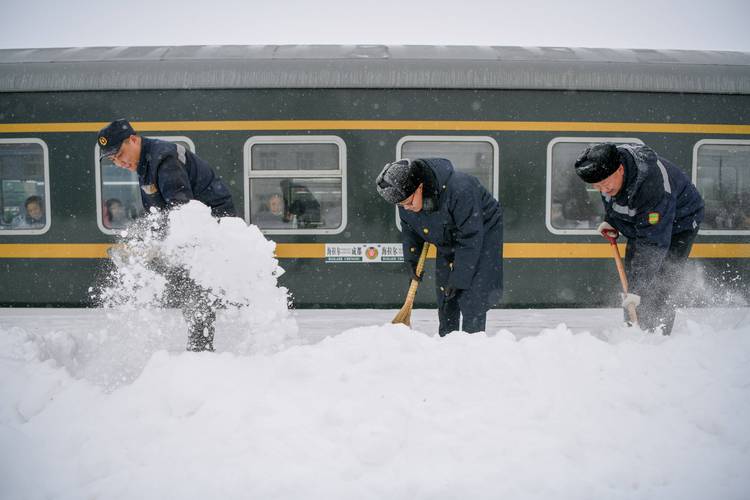 11月19日,中国铁路呼和浩特局集团有限公司大板站职工在清理站台积雪.