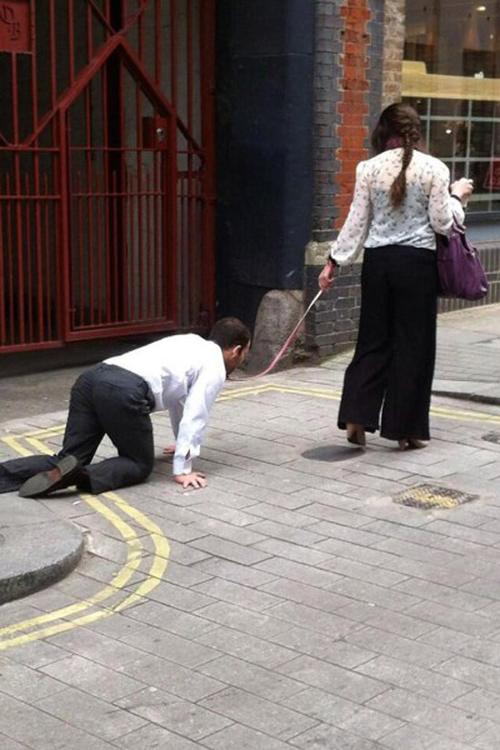 英国街头惊现一女子"遛男人" 男子在街上爬行