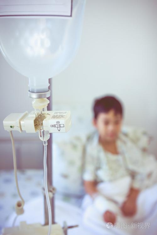 亚洲小男孩坐在病床上与输液泵静脉点滴