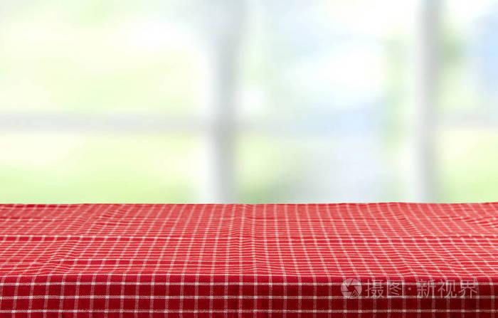 带红色格子桌布和明亮背景的空桌子.为您的食品和产品展示蒙太奇