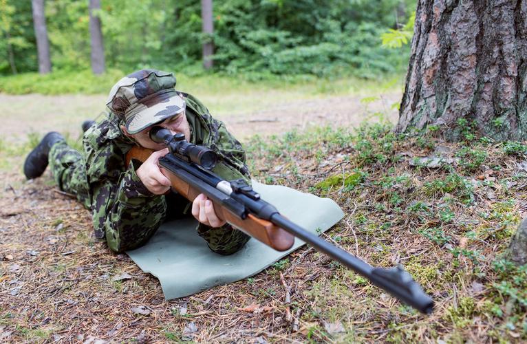 狩猎战争军队和人的概念年轻的士兵护林员或猎人用枪在森林里