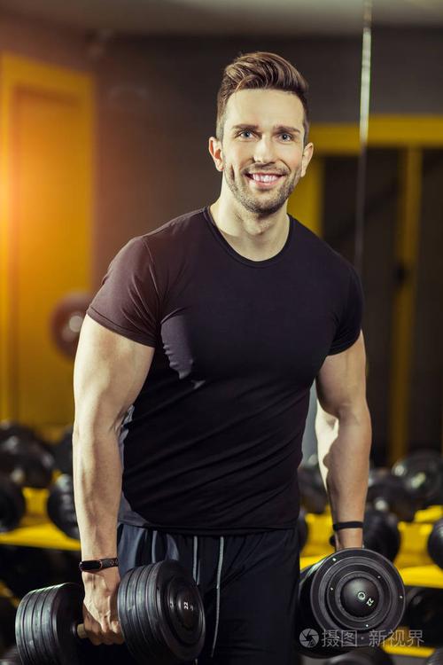 健康生活方式运动强壮的肌肉男在健身房锻炼,用哑铃锻炼二头肌