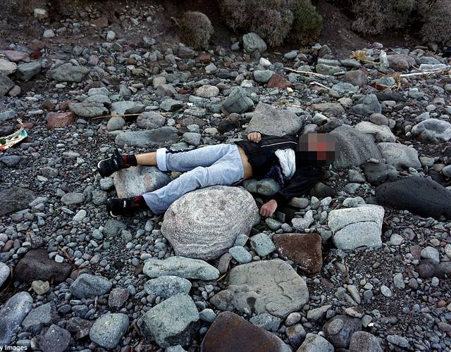 一名孩子的尸体孤零零地躺在海滩上.