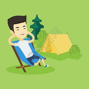 坐着 户外坐在露营地背景上坐在椅子微笑的男人享受露营假期的轻松