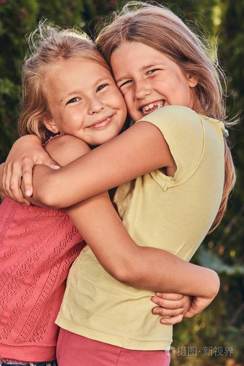 特写肖像两个快乐的女朋友拥抱在公园