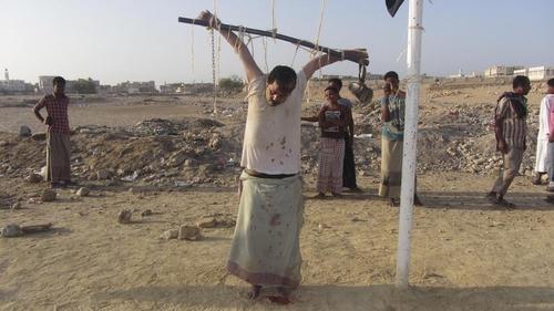 也门基地组织枪毙美国间谍 ,尸体悬挂在球门上示众.