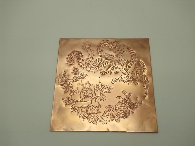 学习传统錾刻工艺,在金属铜上面錾刻龙凤花纹图案.