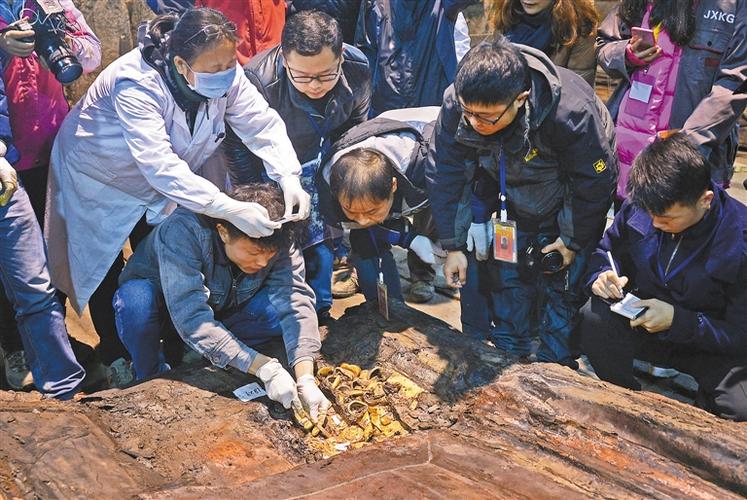 12月24日,考古人员在清理现场提取金饼.