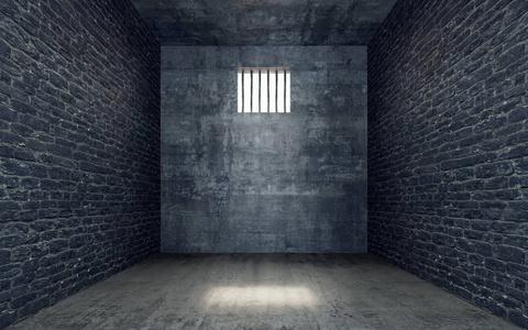 用光,透过铁栅栏的窗户照进来的监狱牢房照片