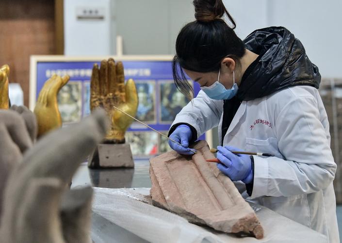在大足石刻研究院文物修复室,工作人员在对石质文物进行清理(12月10日