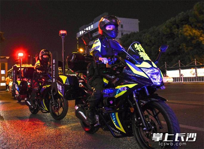 女子特警大队队员骑着警用摩托车在长沙街面上巡逻.
