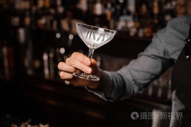 酒吧招待手拿着一个空的鸡尾酒玻璃照片-正版商用图片0fbsr0-摄图新