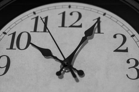 分钟晚特写时钟的指针,标记在十点后五分钟的黑白渲染.