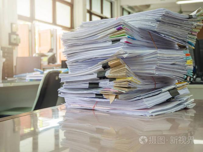 经营理念,堆未完成的工作文件在办公室桌上,堆栈的商务用纸照片-正版