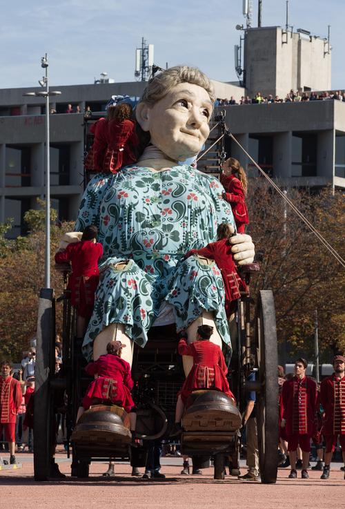 工作人员操作巨型木偶"巨人小女孩"在街头行走,场面壮观!