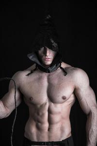 赤身露体,头戴尖顶头巾的吓人的肌肉男青年照片