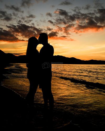 夕阳海滩上的情侣亲吻剪影