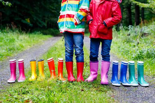 小朋友们, 孩子们穿着五颜六色的雨靴.孩子们站在秋天的森林里.